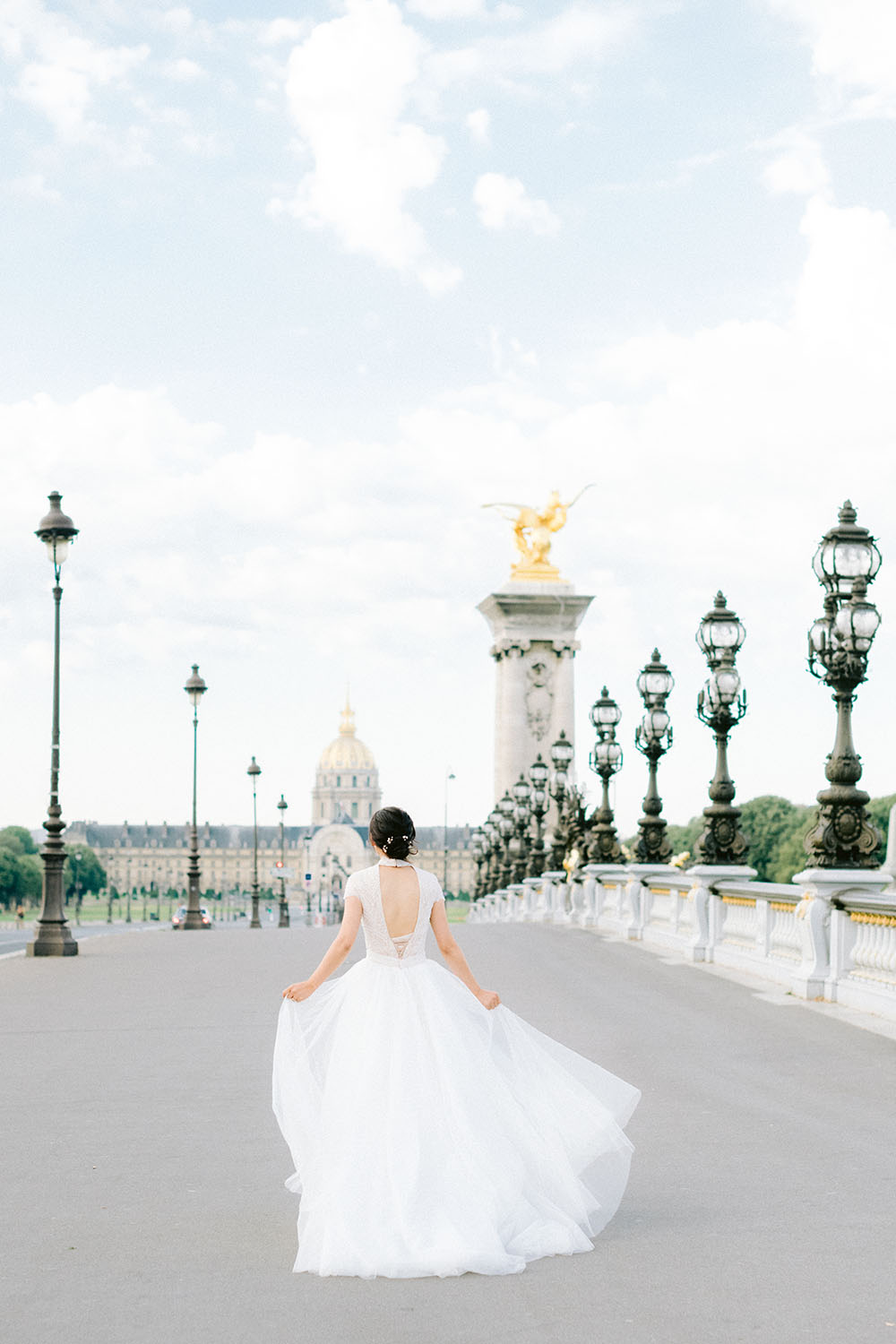 a bride run on the bridge alexander 3 with her wedding dress ersa atelier